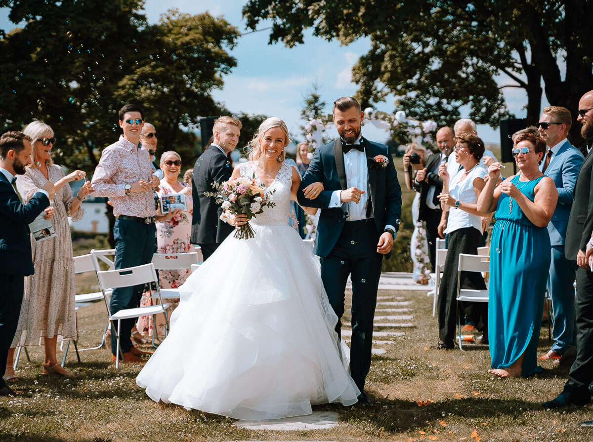 bride and groom coming down the aisle together after an outdoor ceremony