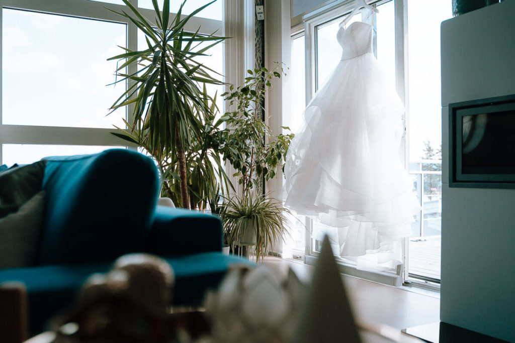 White wedding dress hanging in a window sill
