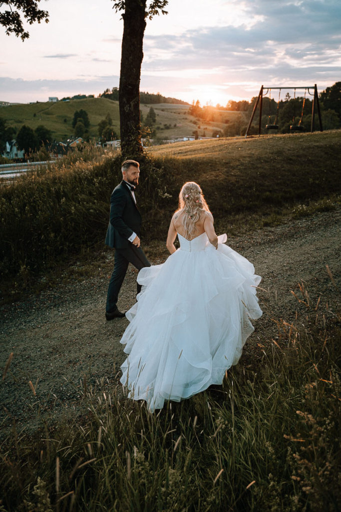 Bride and groom walking in tall grass in Kjeller Gård, Lillestrøm